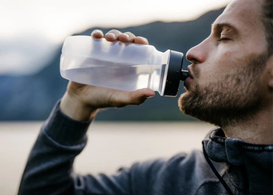 Homme s'hydratant avec une gourde