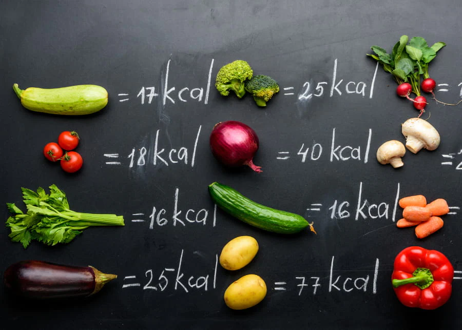 Légumes et leurs valeurs caloriques inscrits sur un tableau noir