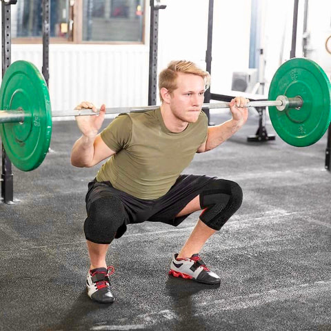 Athlète au squat avec une barre chargée