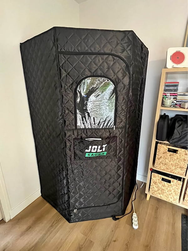 Cabine du JOLT Sauna montée dans une pièce, branchée sur une prise secteur