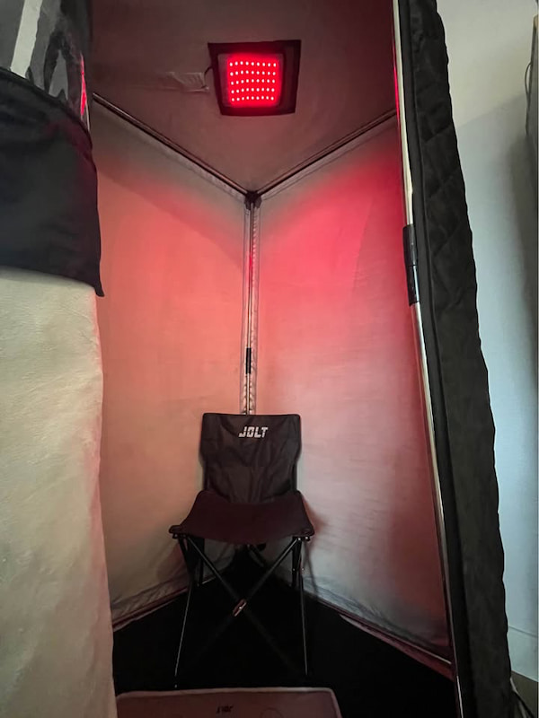 Intérieur du JOLT Sauna avec le panneau de luminothérapie rouge allumé au plafond