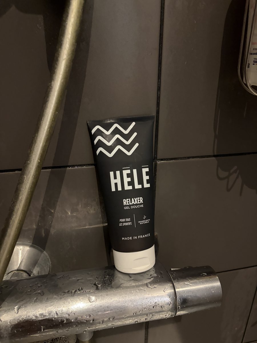 Tube HÉLÉ Relaxer gel douche 200 ml posé sur la barre de douche après une séance