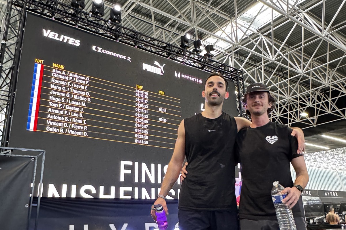 Gabin Berthet et Vincent devant l'écran des résultats de l'HYROX Toulouse affichant leur chrono de 1h14