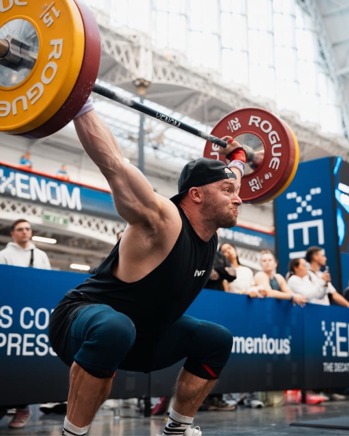 Athlète en réception de squat snatch avec une barre Rogue lors de l'épreuve 001 du XENOM London 2026